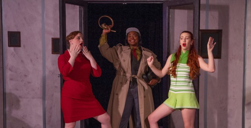 Three drama students on stage posing