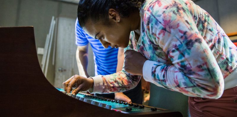A student adjusting the audio engineering equipment