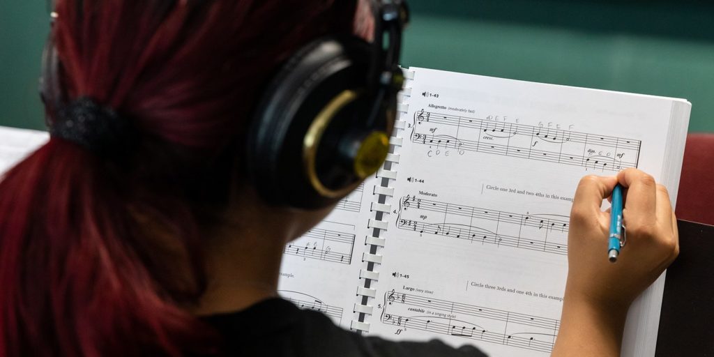 A student making notes on a music sheet