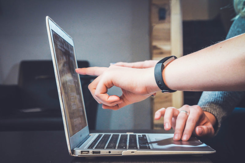 Hands pointing to a laptop