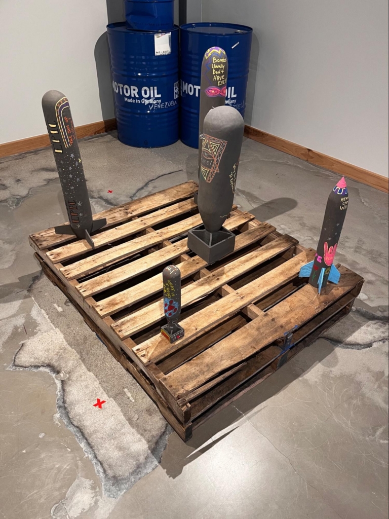 The finished sculptures reflect layers of shared creative transformation, featuring optimistic phrases and imagery in vivid colors.