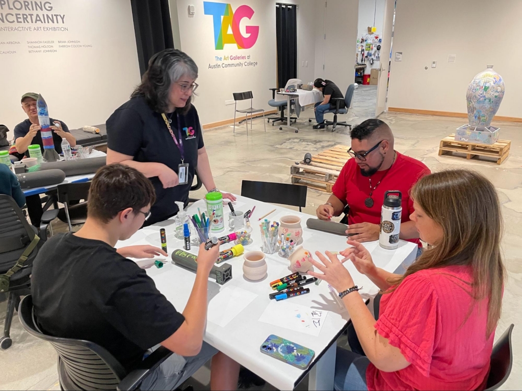 ACC alumna and TAG Gallery Tech Gina Woodruff helps participants begin the artmaking process.